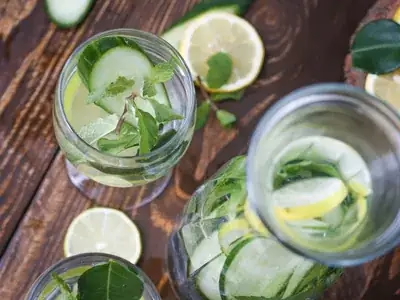 Jarra de água detox transparente com rodelas de pepino e folhas de hortelã