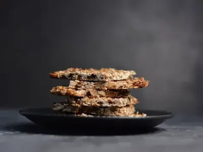 Barrinhas de cereal douradas cortadas em quadrados sobre tábua de madeira