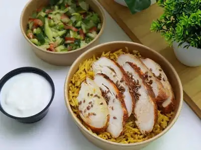 Frango desfiado temperado sobre arroz integral em prato branco