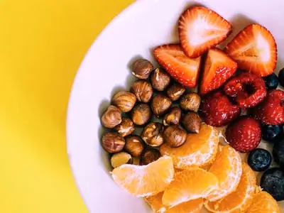 Tigela colorida com mix de frutas frescas e castanhas variadas