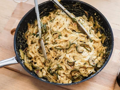 Espaguete de abobrinha com molho branco cremoso e parmesao ralado em prato fundo