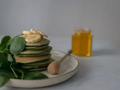 Panquecas de banana empilhadas com mel e frutas vermelhas