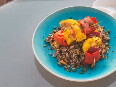 Bowl de quinoa branca com legumes grelhados coloridos e ervas frescas