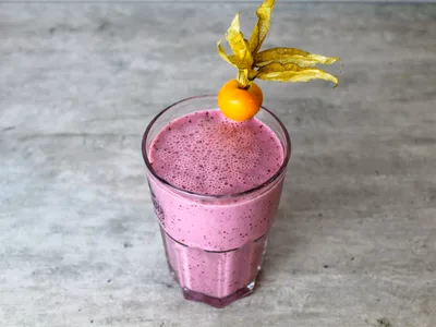 Vitamina saudavel de banana com canela em copo alto com palinha e chia por cima