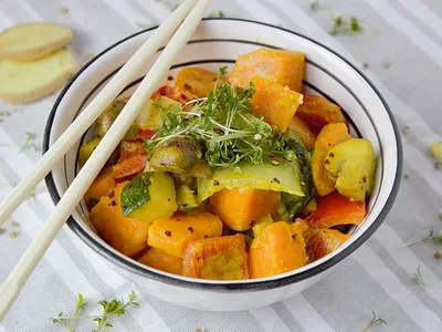 Batata-doce assada aberta com pasta de amendoim e banana fatiada em prato branco