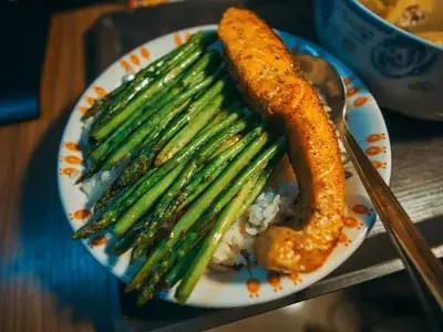 Filé de salmão rosado assado sobre aspargos verdes com rodelas de limão