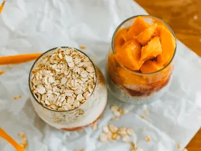 Shake cremoso de aveia e banana em copo alto com canela polvilhada
