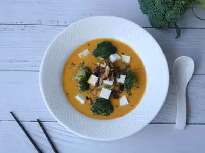 Tigela de sopa de legumes com frango e grão-de-bico em caldo dourado