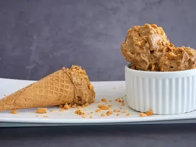 Sorvete cremoso de banana com fio de pasta de amendoim em copo