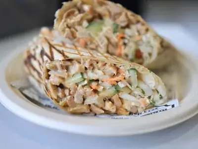 Wrap integral cortado ao meio mostrando recheio de frango e legumes frescos