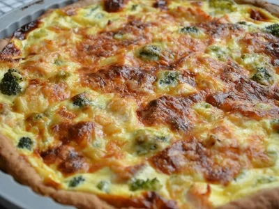 Quiche low carb fatiada em tabuleiro de madeira com salada verde ao lado