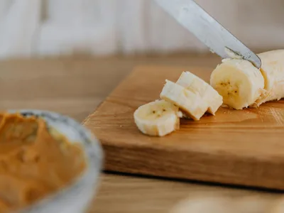 Banana fatiada com pasta de amendoim cremosa em prato branco