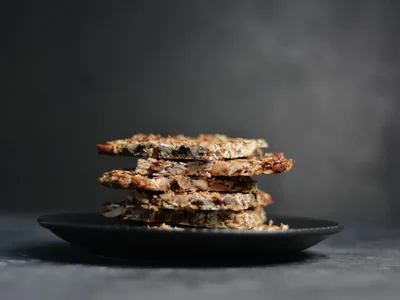 Barrinhas de cereal douradas cortadas em quadrados sobre tábua de madeira