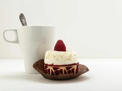 Bolo de caneca low carb de chocolate em caneca branca com cacau polvilhado e colher