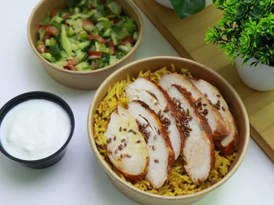 Frango desfiado temperado sobre arroz integral em prato branco