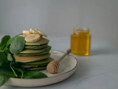 Panquecas de banana empilhadas com mel e frutas vermelhas