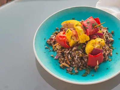Bowl de quinoa branca com legumes grelhados coloridos e ervas frescas
