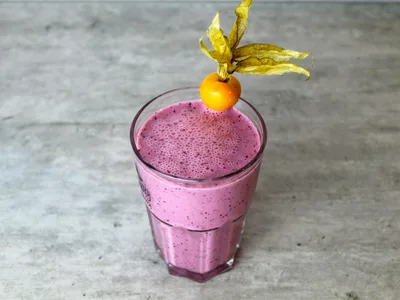 Vitamina saudavel de banana com canela em copo alto com palinha e chia por cima