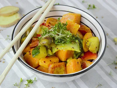 Batata-doce assada aberta com pasta de amendoim e banana fatiada em prato branco