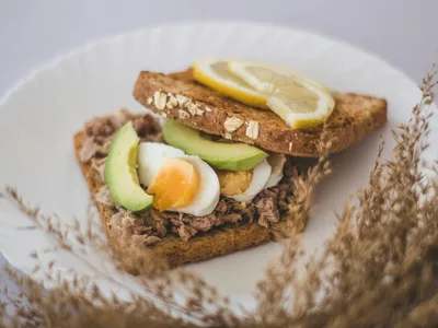 Sanduíche de atum com pão integral cortado ao meio mostrando recheio