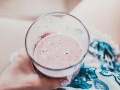 Smoothie rosado de morango com iogurte em copo com morango na borda