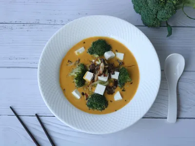 Tigela de sopa de legumes com frango e grão-de-bico em caldo dourado
