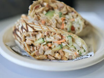 Wrap integral cortado ao meio mostrando recheio de frango e legumes frescos