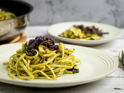 Zoodles com pesto verde em prato fundo com tomates-cereja